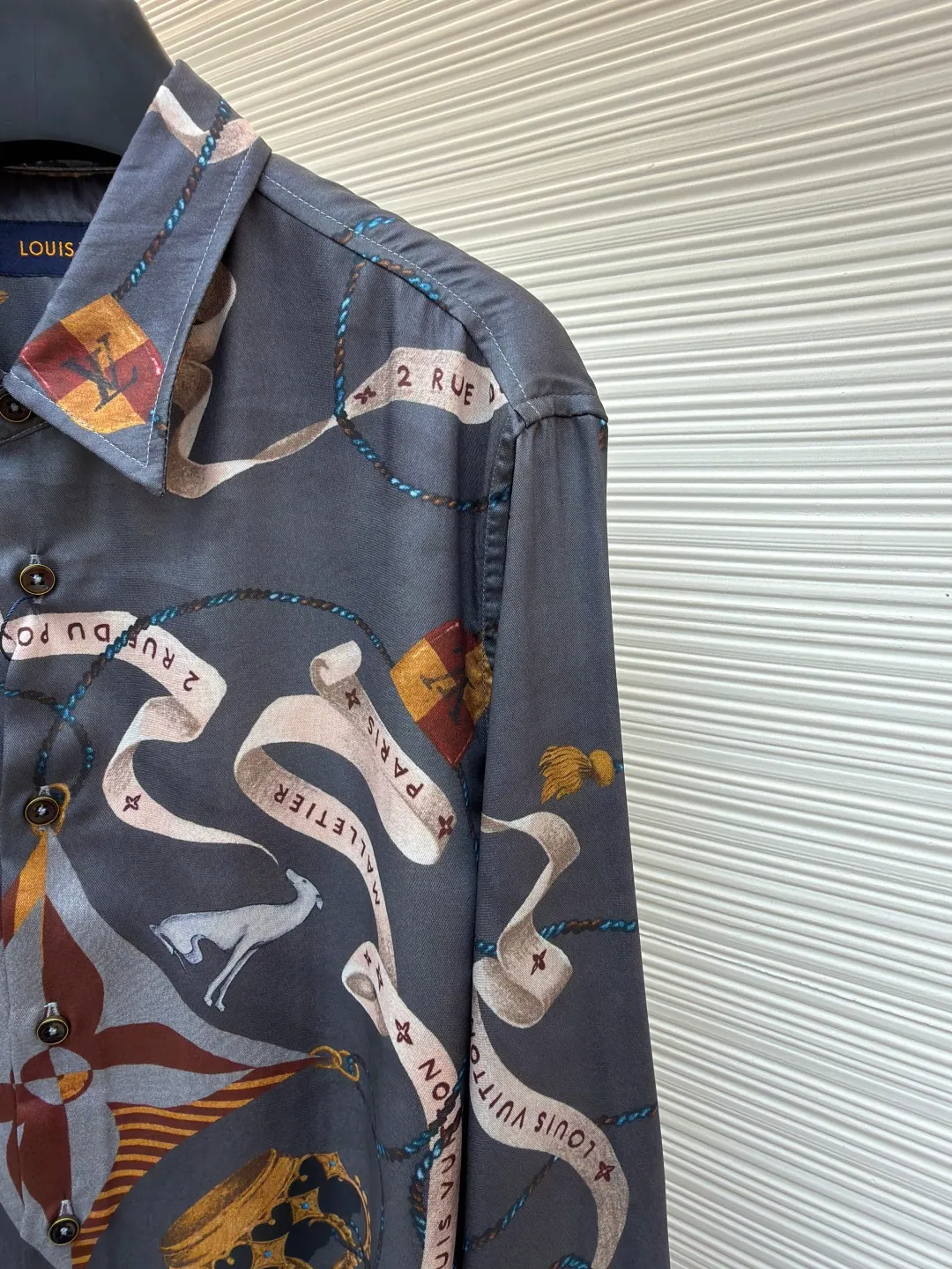 LOUIS VUITTON lapel printed mulberry silk shirt ●Original version: Purchased and developed for 17000 ●Item number: 1682218-A85 ●Fabric: worsted mercerized imitation Tencel fabric ●Technology: made by positioning cutting machine ●Color: gray ●Version: fitted version ●Weight: about 190 grams ●Size: S-M-L-XL ●Description: This printed long-sleeved shirt is made of 19mm mulberry silk and cotton blended fabric, which is made through high-density weaving process. The fabric combines the smooth luster of silk with the crisp and breathable characteristics of cotton, and has excellent wrinkle resistance and drape. The body printing adopts digital direct inkjet printing combined with manual overlay screen printing process. First, digital direct inkjet is used to restore the delicate texture and gradient color of the crown, ribbon and other patterns, and then manual overlay screen printing is used to superimpose metallic texture ink to make the three-dimensional relief and glossiness of the pattern more prominent. After high-temperature fixation and water washing tests, the color fastness reaches level 4 or above. The collar of the shirt adopts an inlaid collar design, which is combined with high-temperature pressing and shaping technology to make the collar stiff and not easily deformed; the placket is made of hand-locked hemming technology, and the buttons are made of natural horn buttons, each of which is polished by hand; the side seams are made of French double-needle chain stitching, and the cuffs are designed with adjustable cuffs, showing fine workmanship in every detail. The overall wiring is straight and delicate, the fabric is comfortable and soft, and the color is consistent without color difference. It can be matched with the same style to create a fashionable look and control various occasions. Customized accessories, complete with three standards, same style for men and women!